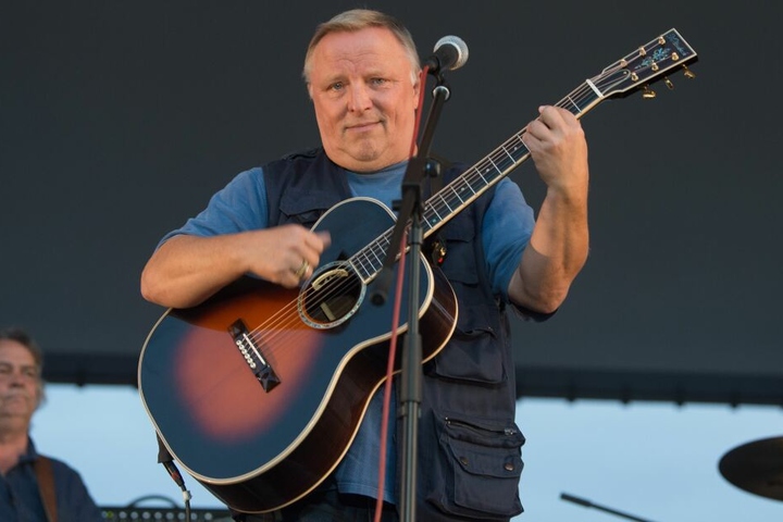 Axel Prahl steht während eines Konzerts mit seiner Gitarre auf der Bühne.