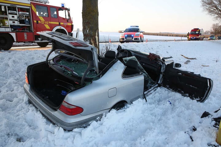 Ein demoliertes Fahrzeug, mit dem eine Familie verunglückte, steht nach einer Kollision mit einem Baum im Schnee neben der Bundesstraße 465.