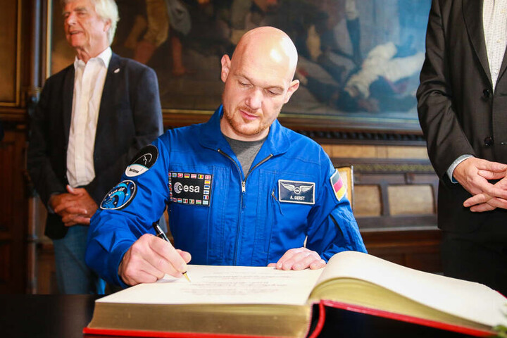Alexander Gerst, während er sich ins Goldene Buch der Stadt einträgt.