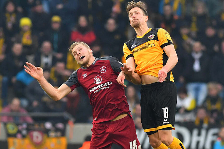 Augen zu und durch: Der Nürnberger Hanno Behrens (l.) und Jannik Müller (r.) steigen zum Kopfballduell hoch.