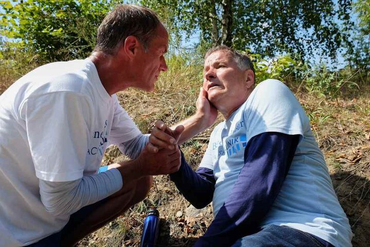 Dr. Roland Heilmann geht es hundeelend: er hat eine Fischvergiftung. Doch sowohl sein Telefon als auch das seines Freundes Dr. Achim Kreutzer (Holger Daemgen, l.) funktioniert nicht und beide wissen nicht, wo sie sind.