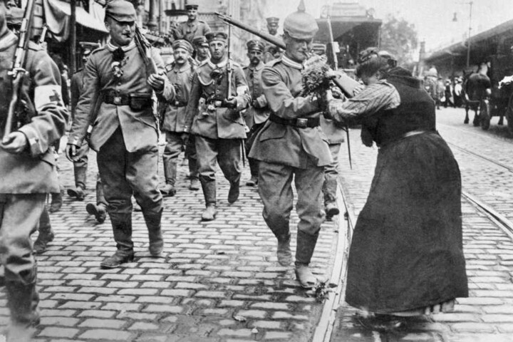 Waffenstillstand 1918: Eine Frau übergibt einen Blumenstrauß an preußische Soldaten, die Berlin verlassen, um an die Front zu ziehen.