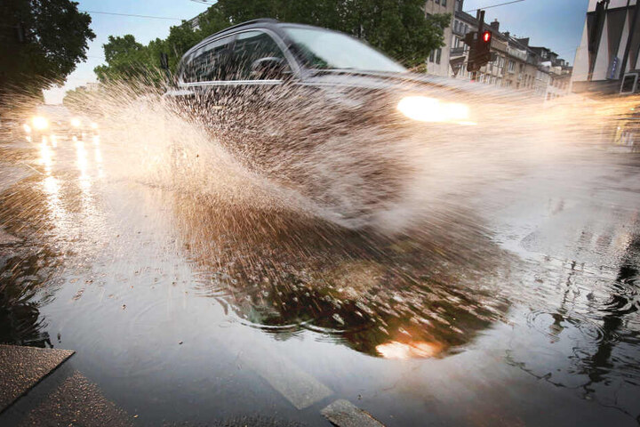 Ein Auto fährt durch eine Pfütze: Ein Bild, an dass sich die Hessen in den kommenden Tagen gewöhnen müssen.