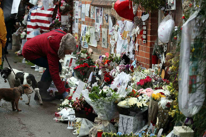 Menschen legen am 25.12.2017 in Goring-on-Thames, Oxfordshire, Blumen, Kerzen, Fotos und andere Gegenstände vor dem Haus des britischen Sängers George Michael nieder, um an dessen ersten Todestag an ihn zu erinnern.