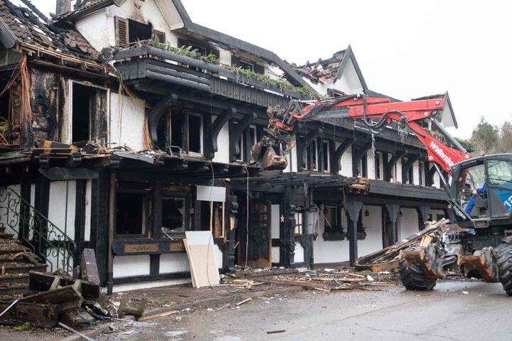 Ein Bagger räumt Schutt vor dem Eingang des ausgebrannten Restaurants des Hotels "Traube Tonbach" in Baiersbronn weg. (Archivbild)