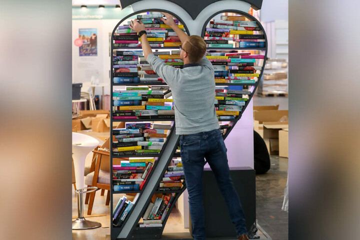 Ein Mitarbeiter bestückt ein Regal auf dem Messegelände. Hier findet von Donnerstag bis Sonntag die geschichtsträchtige Leipziger Buchmesse statt.