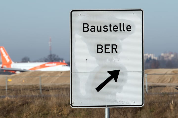 Ein Hinweisschild steht an der Zufahrt zur Baustelle des Hauptstadtflughafens BER.