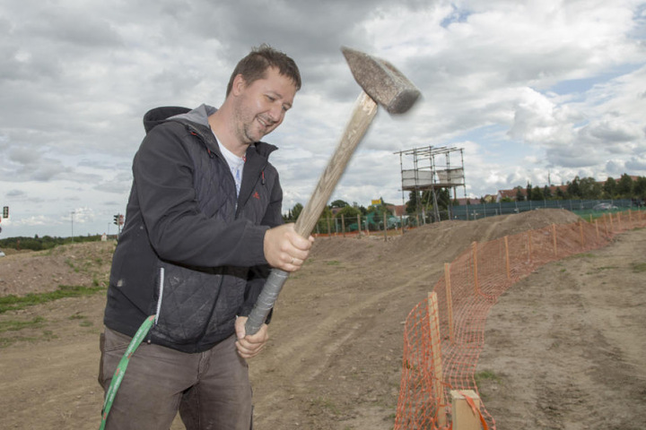 Frank Jorgel (45) schlägt an der Strecke für das Motocross-Rennen Begrenzungspfähle ein.