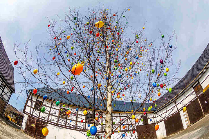 Ein geschmückter Eier-Baum und ein schöner Osterbrunnen zieren den Innenhof des Weidegutes.
