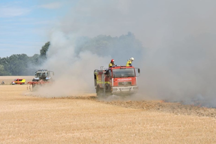 Zwei Feuerwehrmänner löschen die Flammen in Kössern von oben.