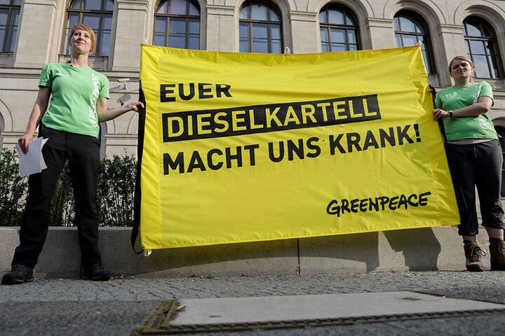 Greenpeace-Aktivisten protestieren vor dem Bundesverkehrsministerium in Berlin mit einem Transparent "Euer Dieselkartell macht uns krank!".