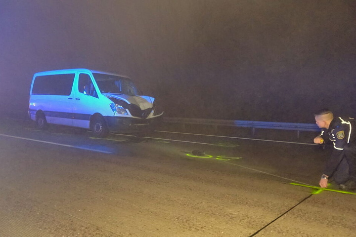 Ein Polizist vermisst und markiert in der Nacht die Unglücksstelle.