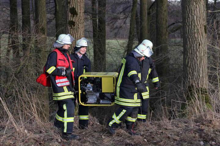 Die Einsatzkräfte tragen ein Stromaggregat vom Unfallort.