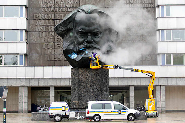 Mit einem Hochdruckreiniger wird das Monument am Freitag von der Farbe befreit.