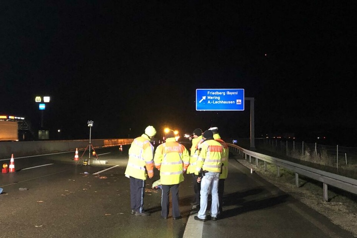 Polizisten stehen an der Unglückssteller auf der Autobahn 8 bei Friedberg.