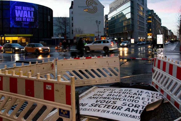 Die beschädigte Replik des berühmten Schildes am Checkpoint Charlie liegt nach dem Sturm auf der Straße.