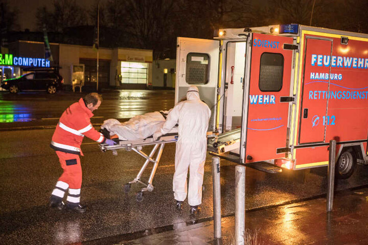 Sanitäter bringen einen der Bewohner in einen Rettungswagen.