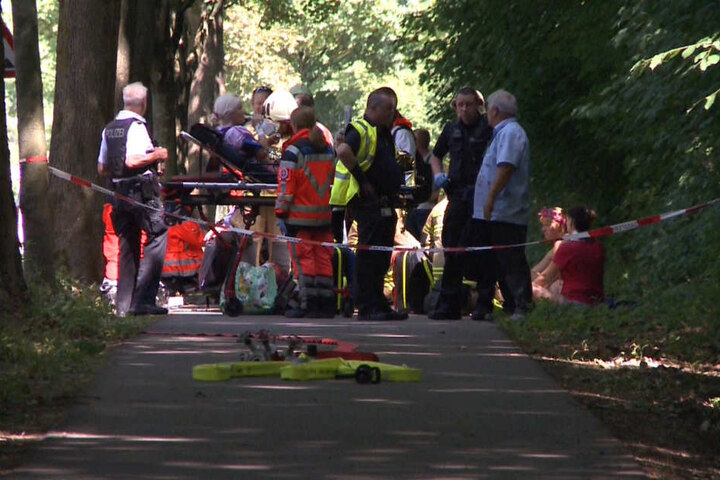 Hinter einer Polizeiabsperrung werden die Fahrgäste von Einsatzkräften der Feuerwehr versorgt.