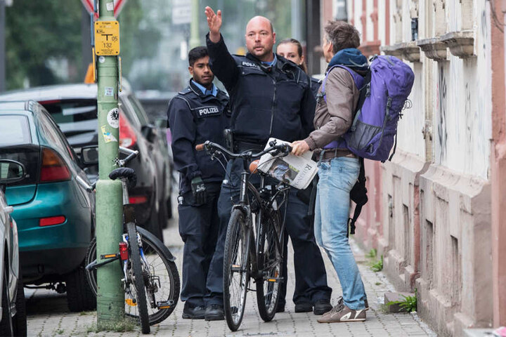 Zwei Polizisten und zwei Anwohner unterhalten sich im Sperrgebiet Frankfurt-Westend.