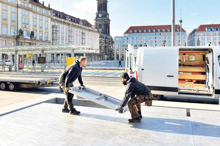 Winter adé! Frank Dietze (41, li.) und Sebastian Stephan (28) von der Holzwerkstatt Dietze decken den Brunnen vorm Kulturpalast ab.