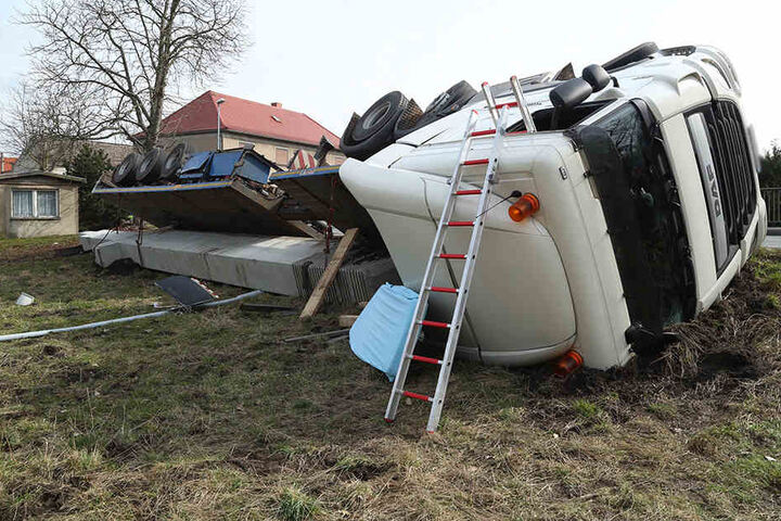 Ein Lkw ist in einer Linkskurve umgekippt.
