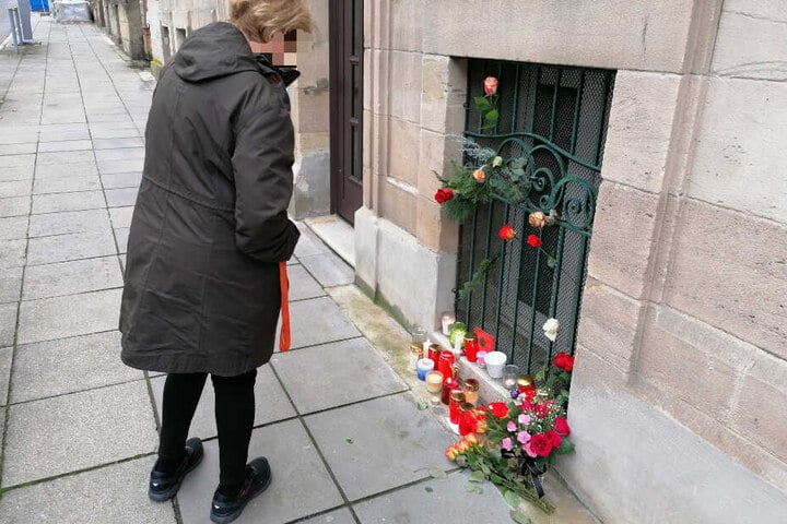 Eine Frau bleibt an der Stelle stehen, an der Menschen der Toten gedenken.