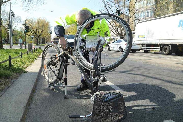 Der Polizist untersucht das verunfallte Fahrrad.