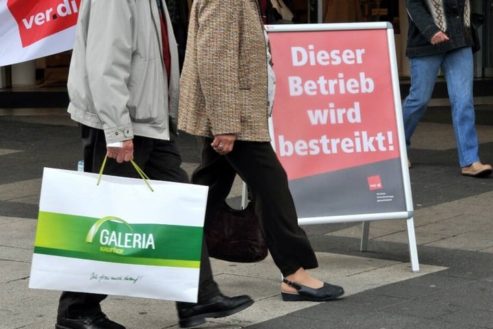 Ein Kunde mit einer Galeria-Kaufhof-Tüte geht an einem bestreikten Betrieb vorbei. (Archivbild)