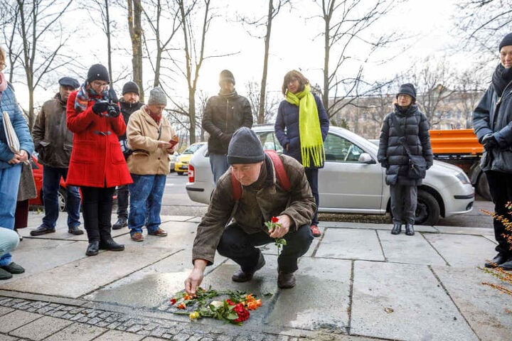 Matthias Krause (67, aus Weimar) legt eine Rose nieder.