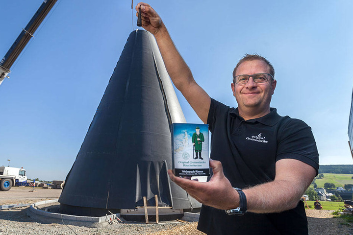 Firmenchef Mirko Paul (39) setzt symbolisch die Spitze auf die einmal 15 Meter Hohe und 9 Meter Durchmesser zählende Kerze.