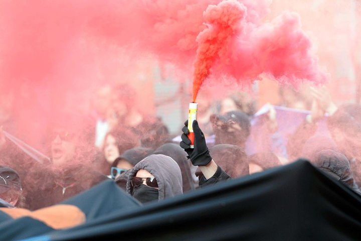 Vermummte Linksradikale mit einem Nebeltopf auf der Demo im Wedding.