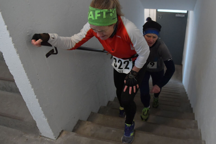 Teilnehmerinnen am "Tower Run" in einem Hochhaus in Gropiusstadt laufen im Treppenhaus nach oben.
