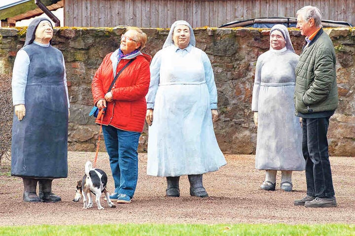Beate (74, mit Hund Nico) und Holger Wrobel (70, r.) aus Chemnitz bestaunen die Figurengruppe "Weltverbesserer".