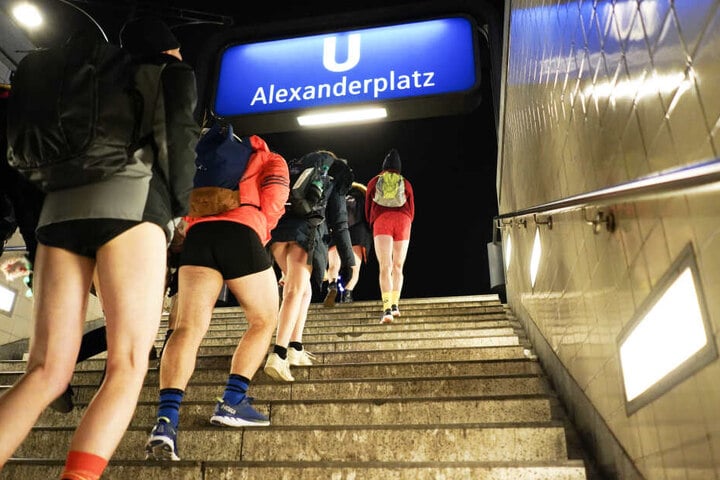 Teilnehmer des Internationalen "No Pants on Subway"-Tags gehen am Alexanderplatz in Berlin aus der U-Bahnstation die Stufen hinauf.