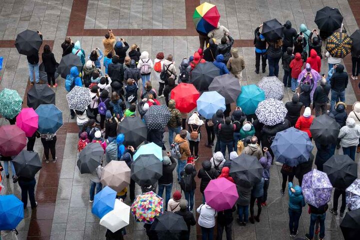 Touristen mit Regenschirmen auf dem Marienplatz in München. Am an diesem Wochenende sollte die Kleidung wetterfest sein.