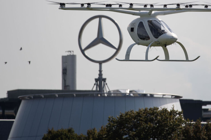 Ein sogenannter Volocopter fliegt in Stuttgart vor einem Gebäude des Autobauers Daimler.