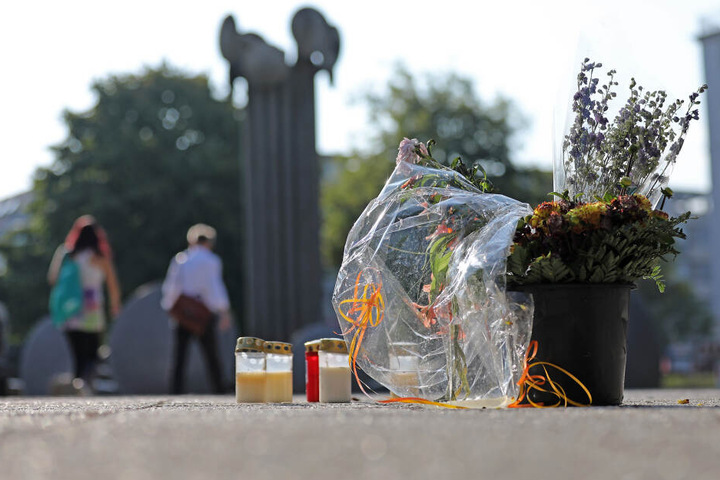 Blumen und Kerzen stehen am Tatort auf dem Ebertplatz.