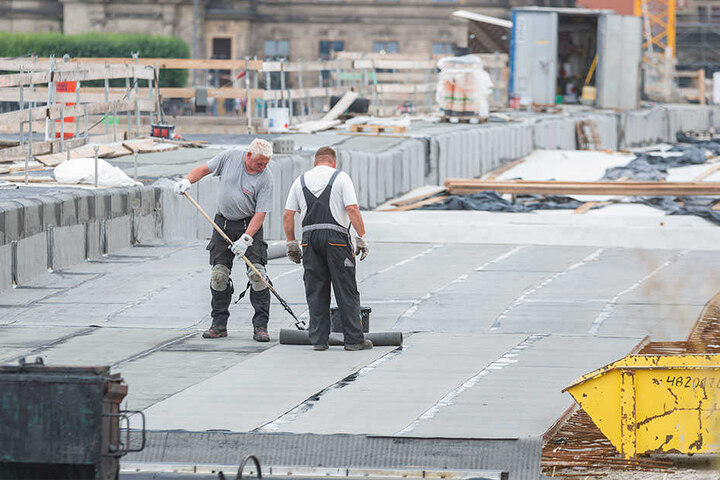 Damit die Brücke künftig dicht bleibt: Arbeiter tragen die neue Bitumenschicht auf.