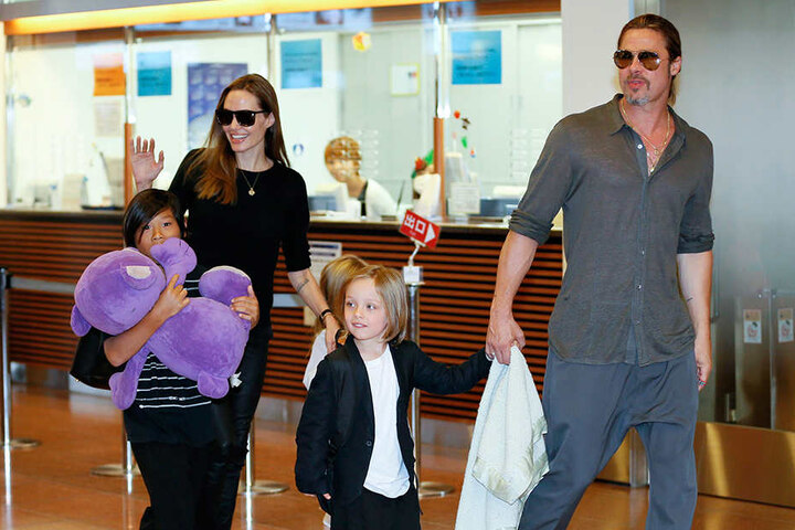 Die US-Schauspielerin Angelina Jolie und ihr Mann Brad Pitt kommen mit ihren Kindern Pax Thien (li), Shiloh (verdeckt) und Knox Jolie-Pitt im Juli 2013 in Tokyo am Internationalen Flughafen Haneda an.