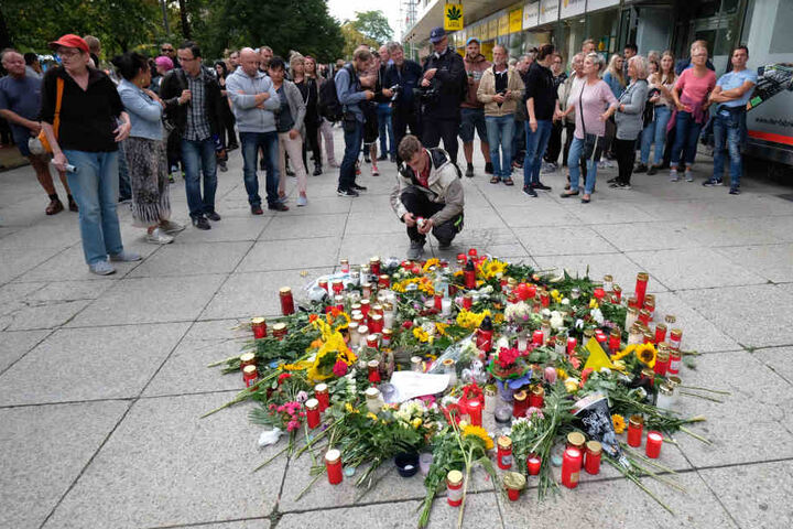 Blumen und Kerzen stehen bzw. liegen am Tatort in der Innenstadt.