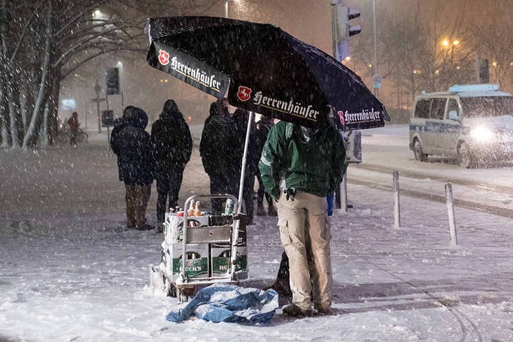 Ein Bierverkäufer trotzt dem Schnee - unterm Schirm verkauft er BIER in Hannover...