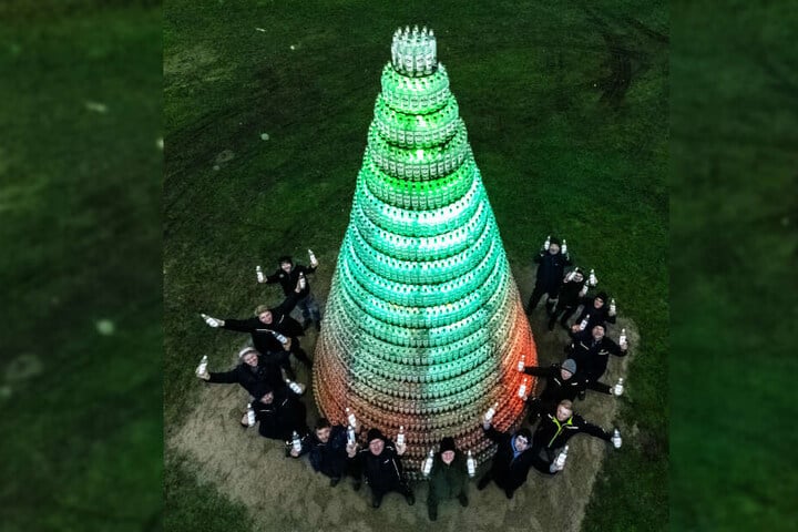 Bauhelfer aus Bendorf-Oersdorf stehen vor ihrer "Schnapsidee", einem Tannenbaum aus 5038 leeren Kornflaschen.