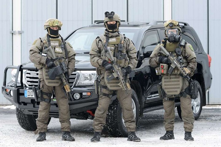 Polizisten stehen vor einem der gepanzerten Toyota Land Cruiser V8.