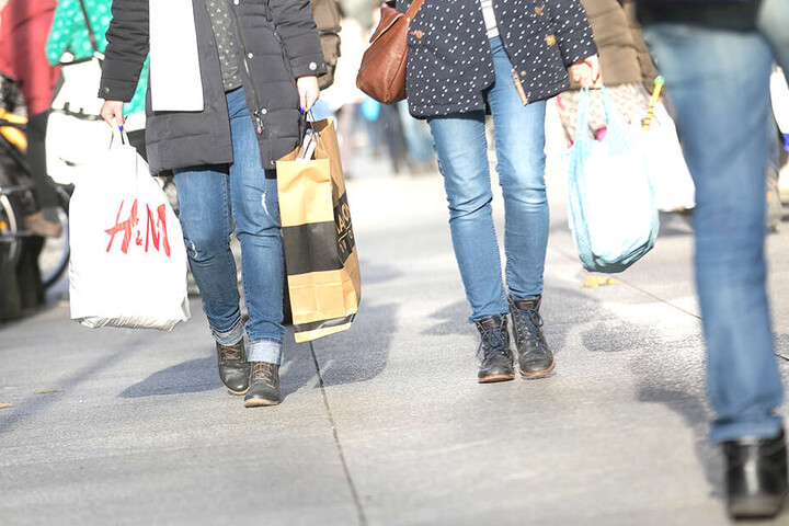 Mit einer H&M-Einkaufstüte in der Hand schlendert eine junge Frau über die Prager Straße.