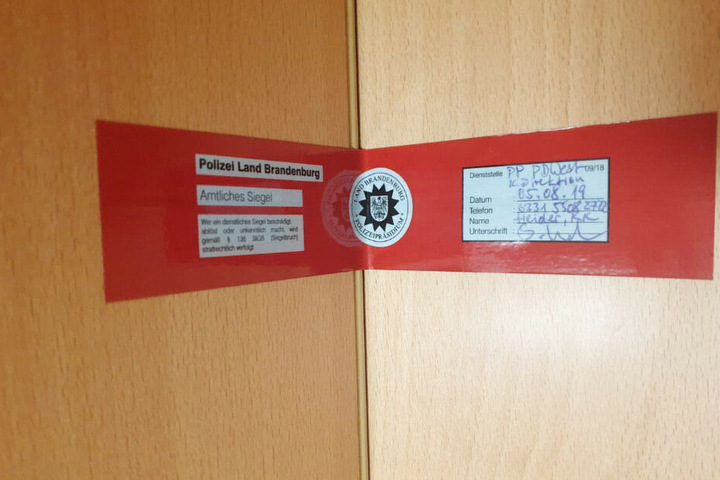 Mit einem Polizeisiegel verriegelt die Polizei die Tür.