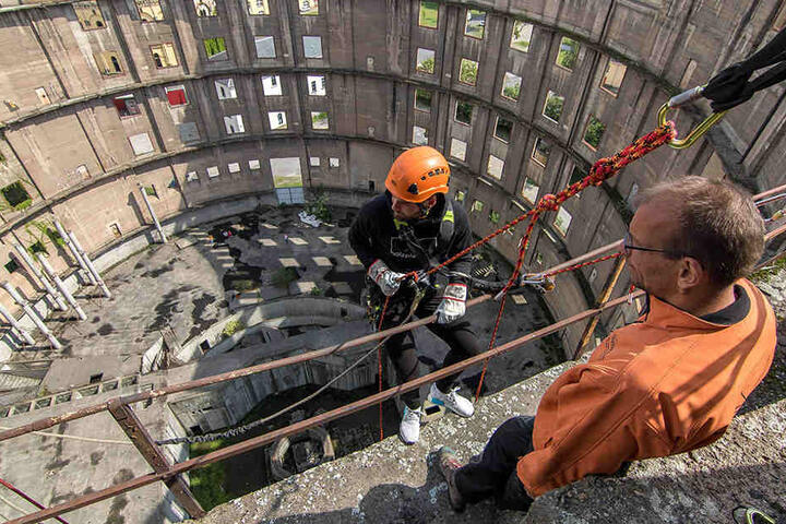 Ein imposanter Blick hinunter: Patrick Wiegers (l.) lässt sich in 43 Metern Höhe die ersten Schritte hinab am Seil von Vertikalis-Geschäftsführer Lars Thielsch erklären.