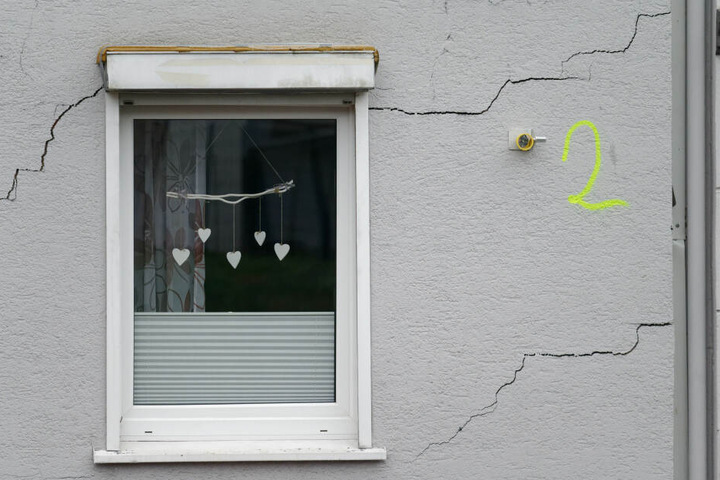 Ein Messpunkt klebt an einem vom Einsturz bedrohtem Haus.