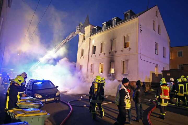 Eine große Rauchwolke steigt aus dem Mehrfamilienhaus aus.