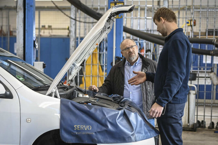Unternehmer Matthias Bähr (61) lässt sich von Kfz-Meister Paul Uhlig (29) die Dienste seiner Werkstatt erklären.