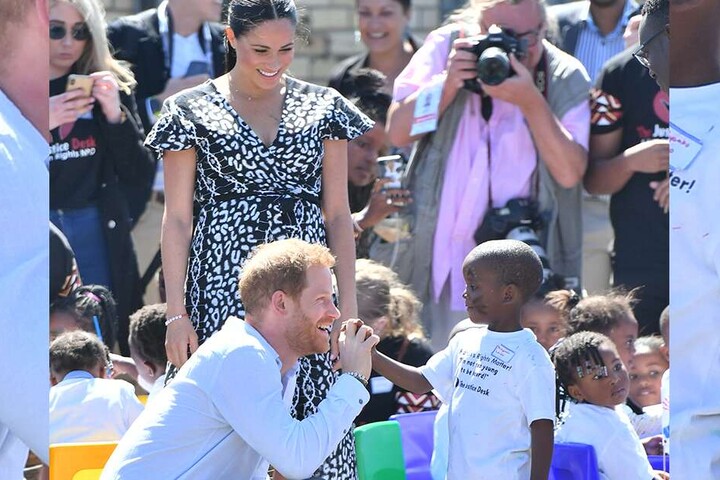 Prinz Harry begrüßt einen kleinen Jungen in der Gemeinde Nyanga.